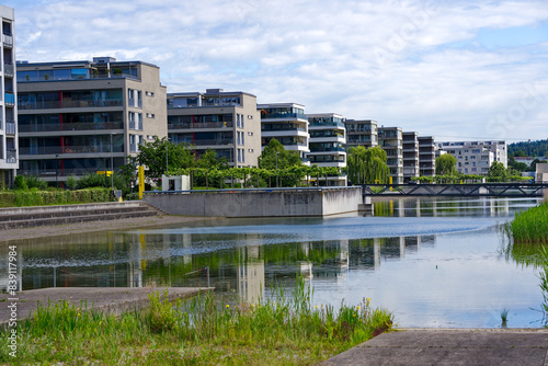 Obraz na plátně Scenic view of public park named Opfikerpark with apartment buildings and pond on a sunny spring day