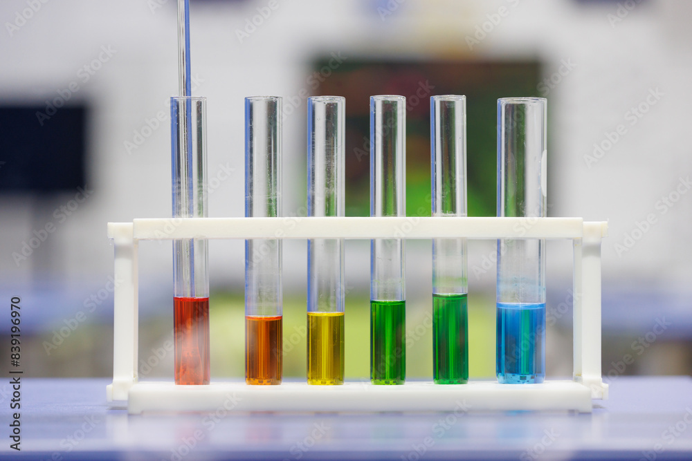 A row of test tubes with different colored liquids in them