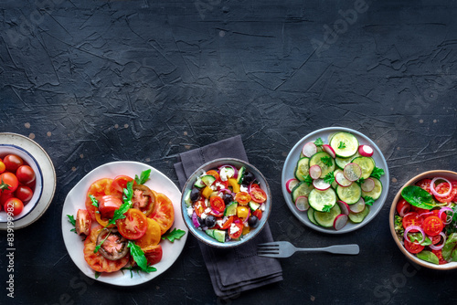 Fresh salads, overhead flat lay shot of an assortment. Variety of plates and bowls with green vegetables. Healthy food, top shot, with copy space