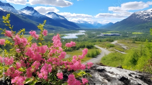 Vibrant pink flowers bloom in the foreground with a breathtaking view of snow-capped mountains  lush green forests  and a serene river valley.