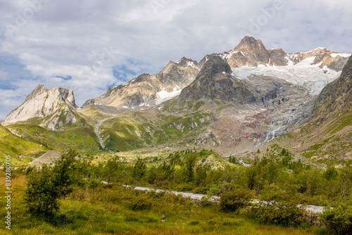 Tour du Montblanc beautiful mountain ladscapes of the Alps green valley, snow summit of Montblanc and rocky peaks of Aiguille du Midi in summer sunny weather blue sky, trekking and hiking in Chamonix