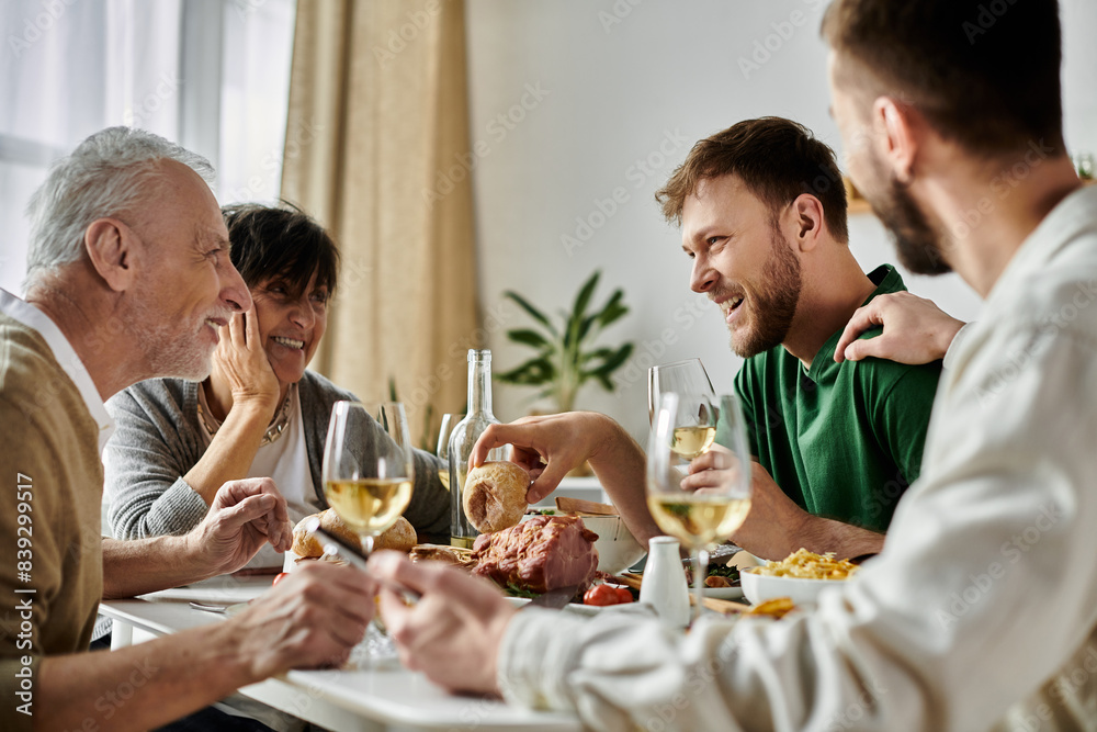 A gay couple enjoys a meal with their family at home. A gay couple enjoys a meal with their family at home.