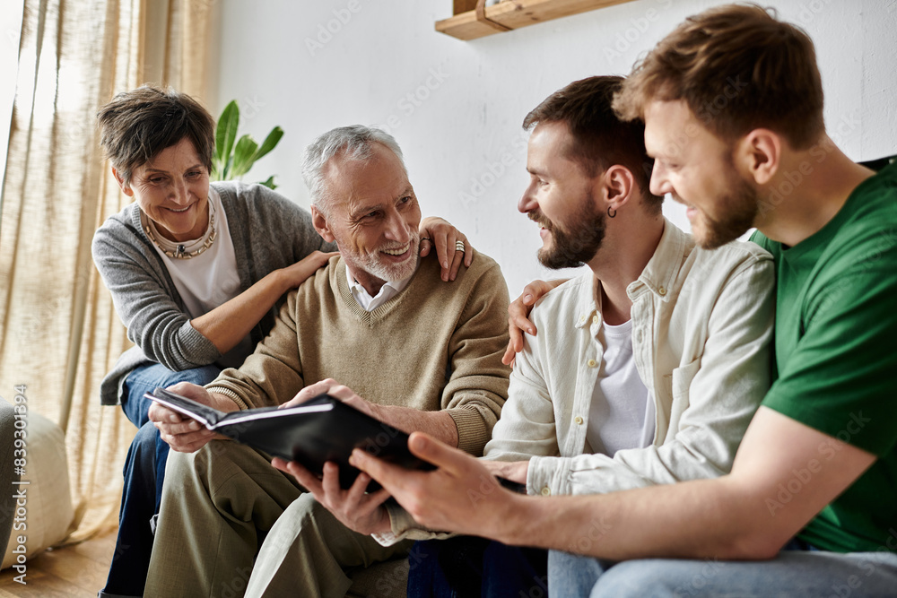 A gay couple shares a photo album with parents, creating a loving and heartwarming family moment. A gay couple shares a photo album with parents, creating a loving and heartwarming family moment.