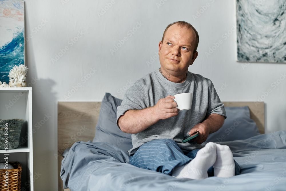 A man with inclusivity sits in bed, enjoying a cup of coffee and his morning routine. A man with inclusivity sits in bed, enjoying a cup of coffee and his morning routine.