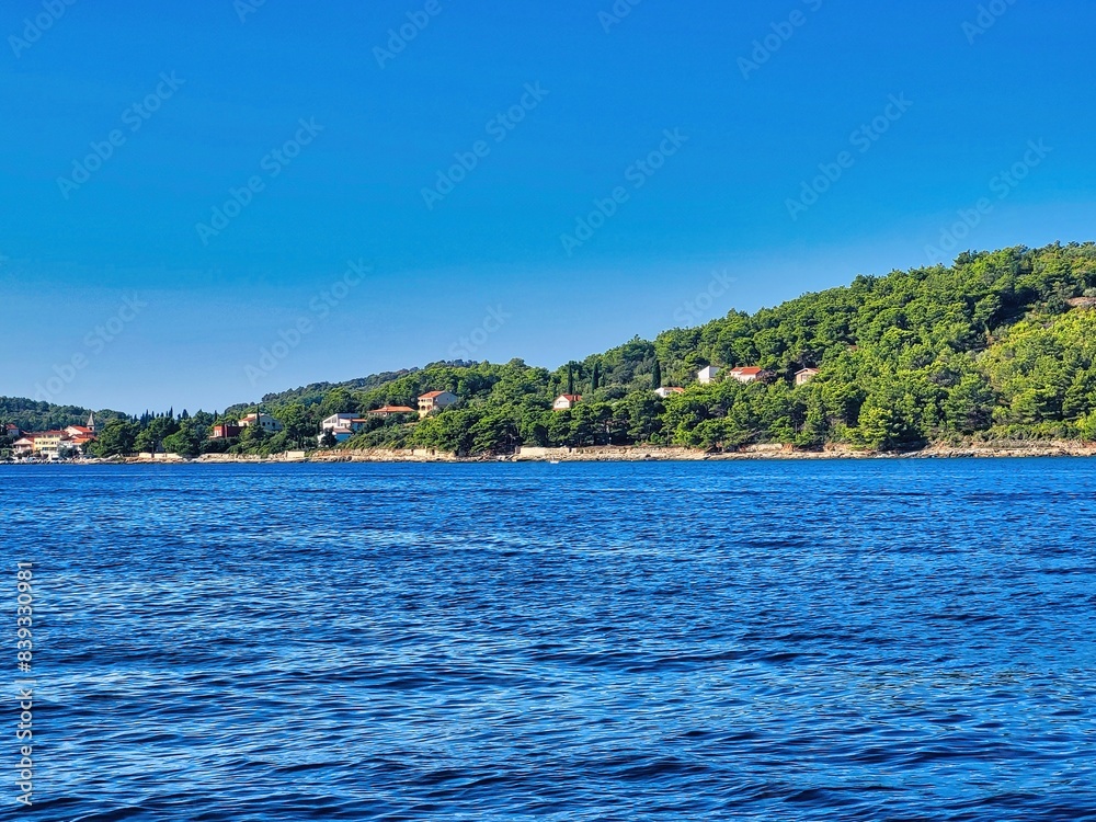 Obraz premium Little rocky-island in the middle around the lake green fields and single rocks. Nature background photo. Holiday vacation background concept. Vacation or holiday or trip or travel concept