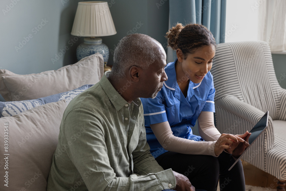 Nurse showing patient health results using a digital tablet on a home visit Nurse showing patient health results using a digital tablet on a home visit