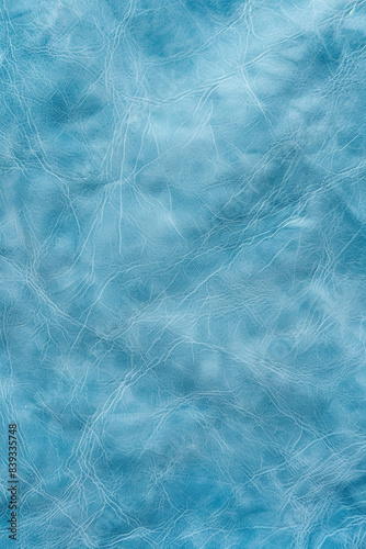 Textured light blue leather surface with intricate patterns  showcasing fine details and cracks  ideal for backgrounds  design  and fashion materials.