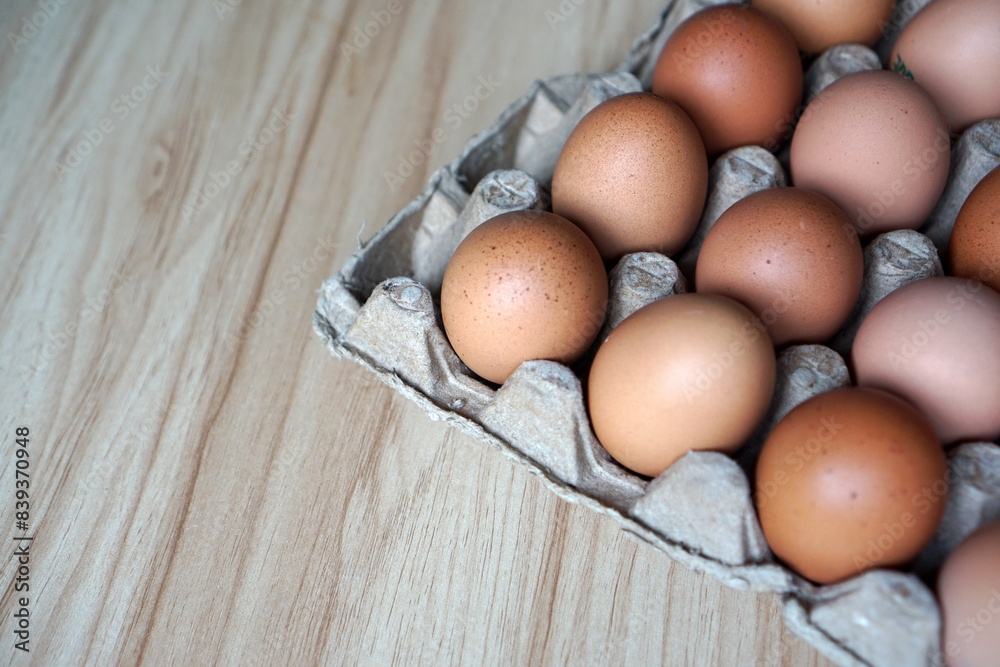 Chicken eggs in egg cartons on a wooden table  