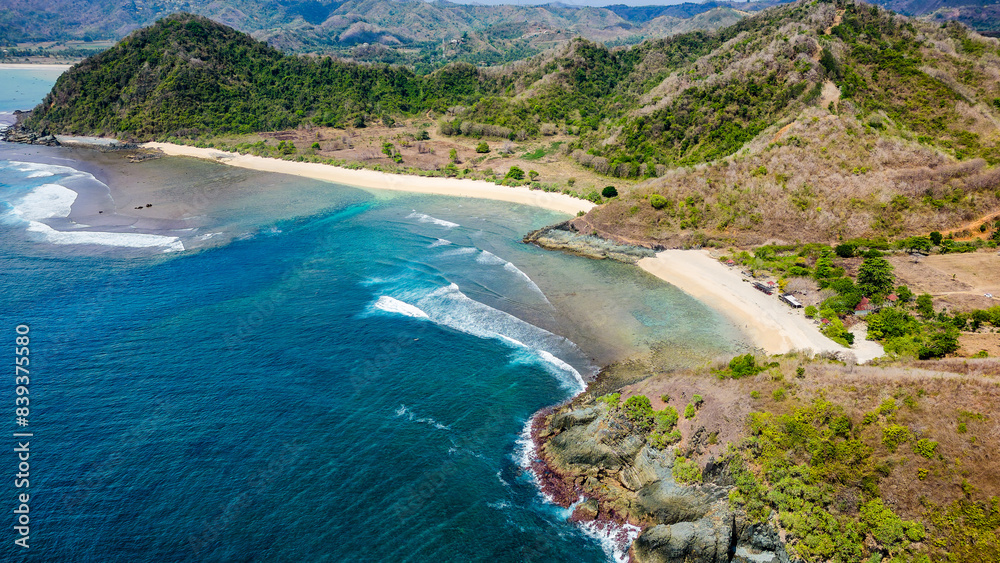 Aerial view of a tiny, deserted tropical beach surrounded by coral reef and blue ocean Aerial view of a tiny, deserted tropical beach surrounded by coral reef and blue ocean