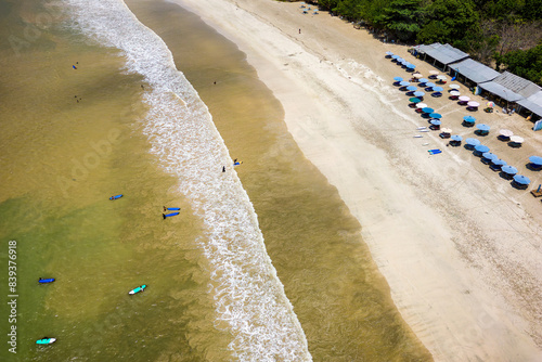 Surfers on the beach and in the ocean at Selong Belanak, Lombok, Indonesia photo