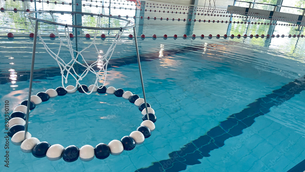 Obraz premium Equipment for water sports and training. A ring for playing water soccer on the surface of the water in the swimming pool. Equipment for water sports and training.