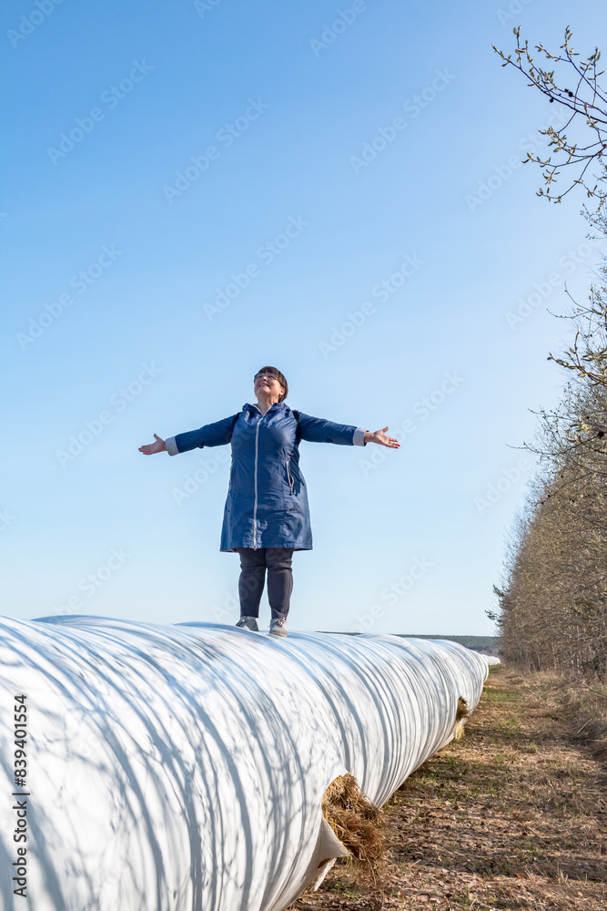 An elderly woman walks through a field in early spring. An elderly woman walks through a field in early spring.