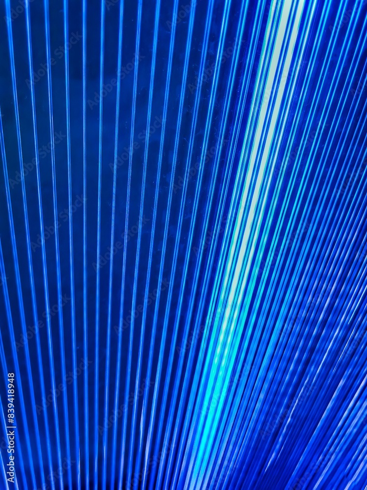 Fototapeta premium Natural green background, closeup tropical palm leaf. Only blue. Blue metal scaffold on the construction building. Blue folds background. Multicolored linear texture. Metal sheet background