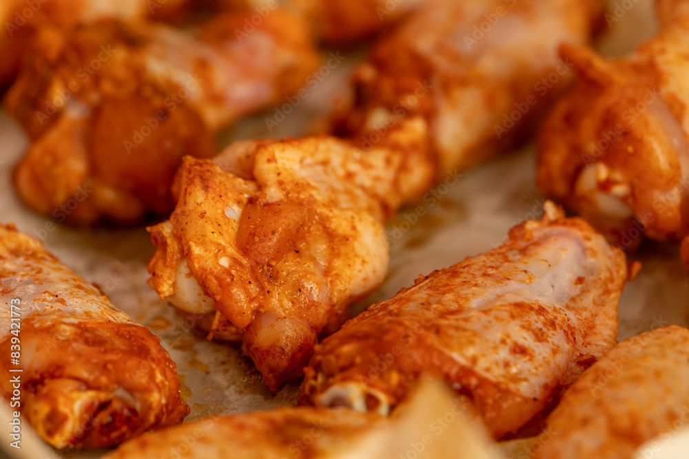 Raw chicken wings in marinade on protwin close-up