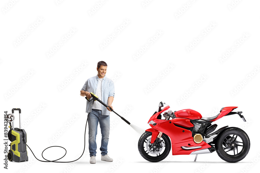Obraz premium Man washing a racing motorbike with a high pressure washer machine