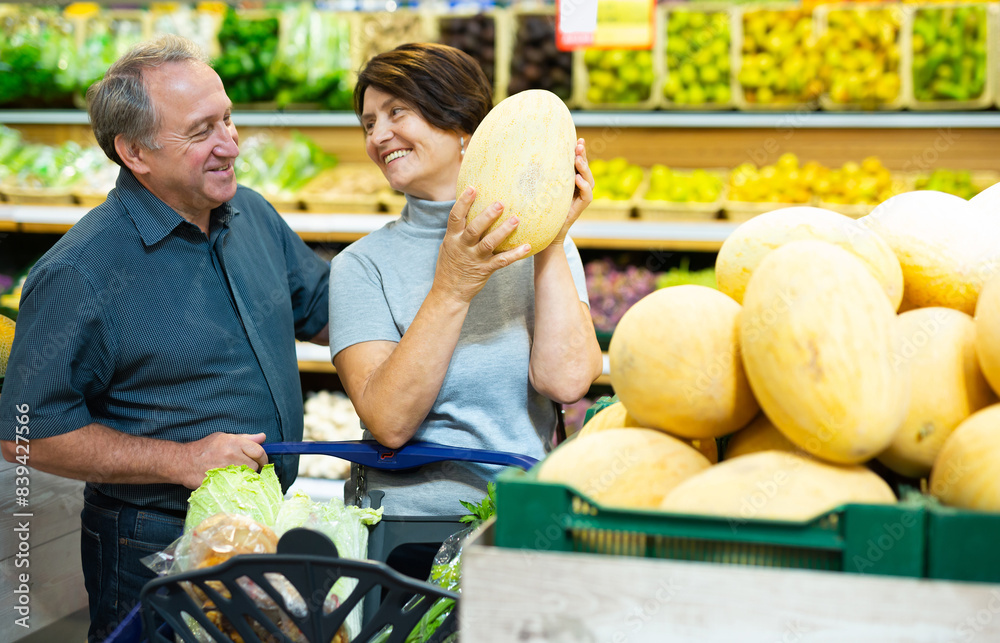 Fototapeta premium Elderly husband and wife choose high-quality melon