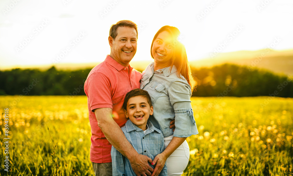 Beautiful father and mother with son on sunset field Beautiful father and mother with son on sunset field