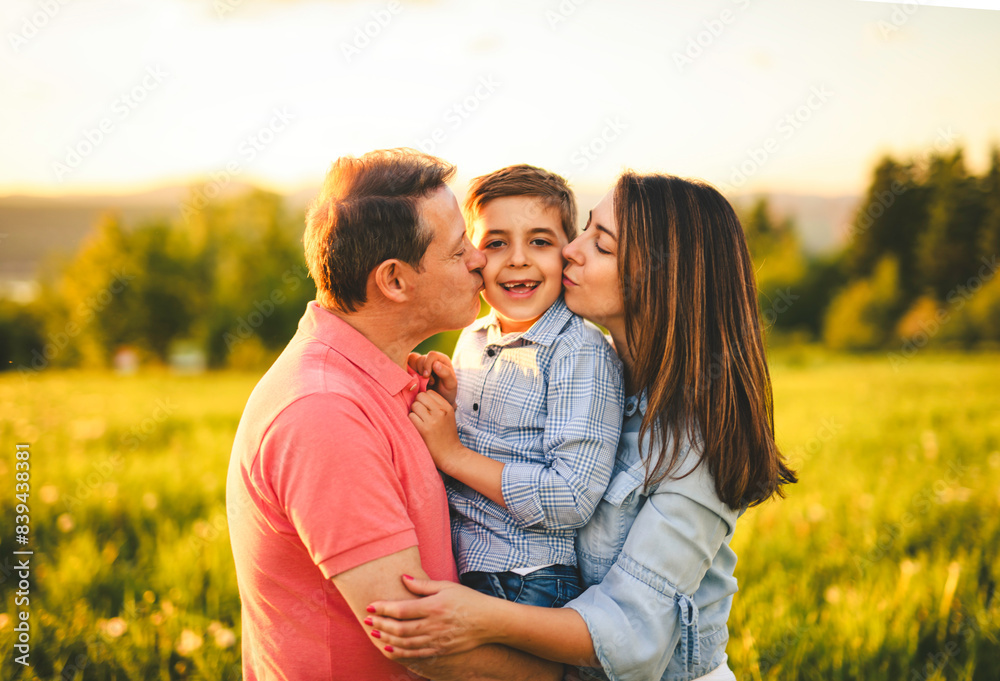 Beautiful father and mother with son on sunset field Beautiful father and mother with son on sunset field