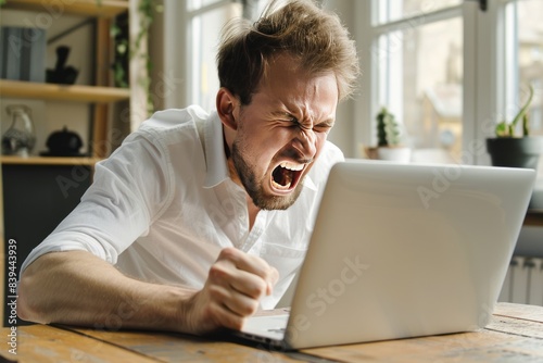 a man angry at a laptop screen, rage , frustrated , stress, mad , furious

