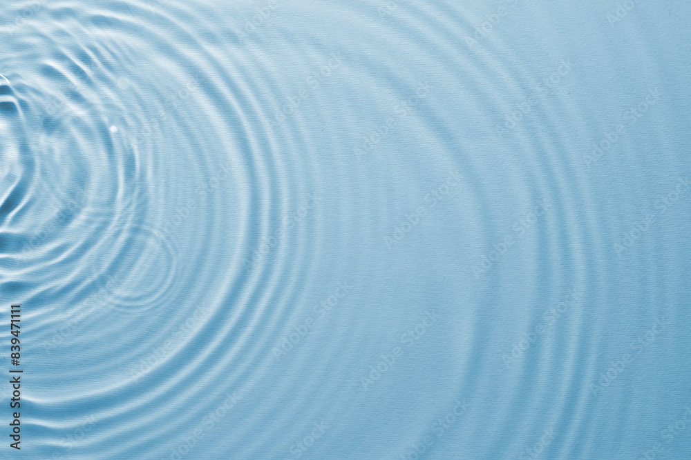 Rippled surface of clear water on light blue background, top view Rippled surface of clear water on light blue background, top view