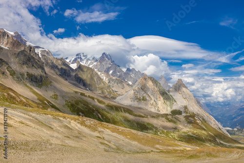 Tour du Montblanc beautiful mountain ladscapes of the Alps green valley, snow summit of Montblanc and rocky peaks of Aiguille du Midi in summer sunny weather blue sky, trekking and hiking in Chamonix