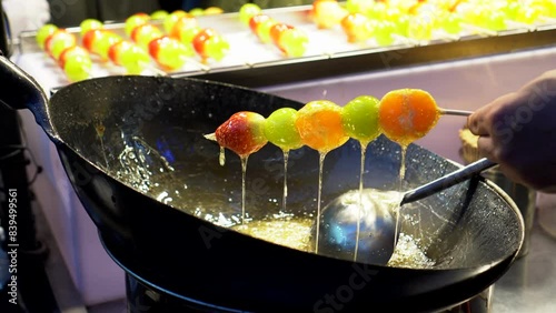 Local street vendor in Hongdae Seoul Korea coat syrup on fresh fruits candy Tanghulu making