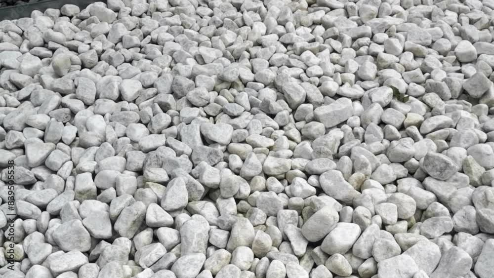 White marble carrara pebbles full fram in zen rockery, camera panning left White marble carrara pebbles full fram in zen rockery, camera panning left