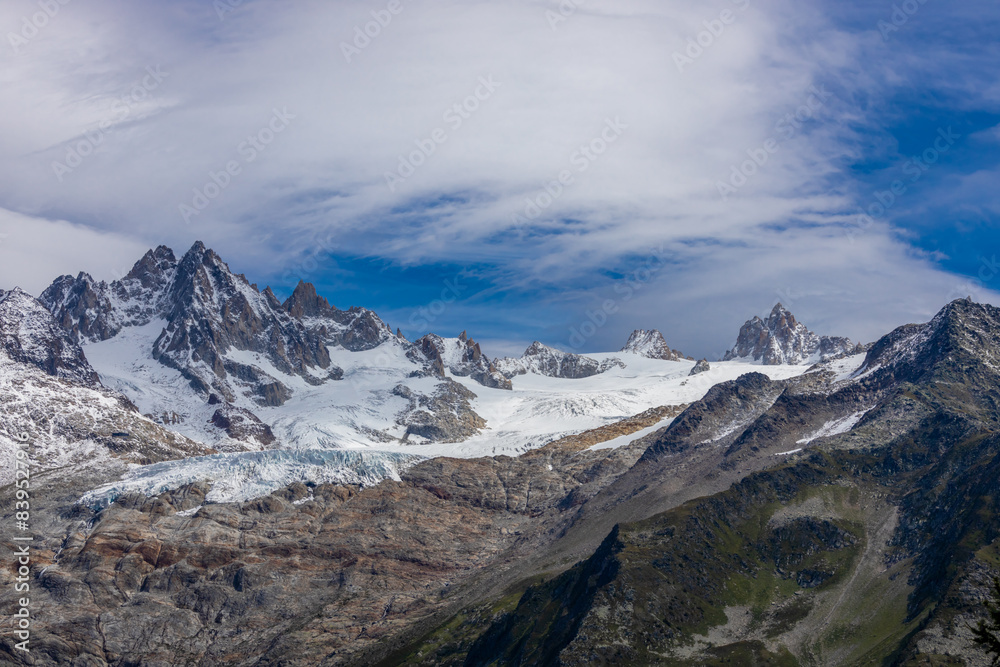 Fototapeta premium Tour du Montblanc beautiful mountain ladscapes of the Alps green valley, snow summit of Montblanc and rocky peaks of Aiguille du Midi in summer sunny weather blue sky, trekking and hiking in Chamonix