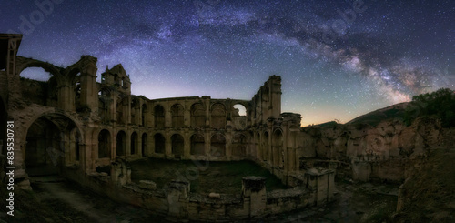Panoramic view on a starry night with the arch of the Milky Way over the ruins of the Rioseco monastery, Burgos photo