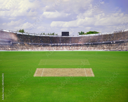 A cricket pitch direct top view of the layout with the grass cricket field. The pitch is inside the field and green field, Cricket match between two teams.