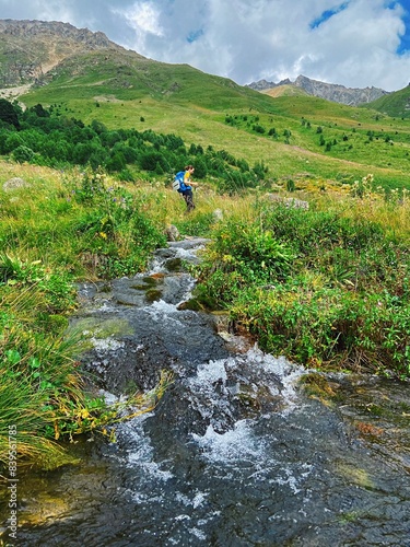 Hiking in the Elbrus mountains against the backdrop of blue sky and green mountains