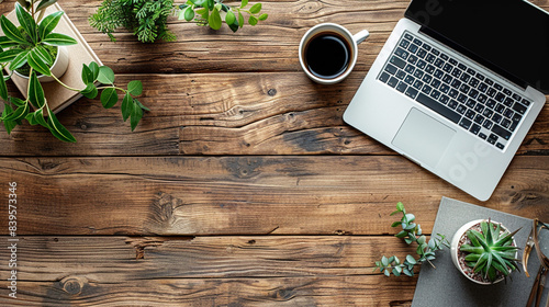 A serene wooden desk adorned with a laptop, coffee, and potted plants, creating a warm and inviting workspace.
