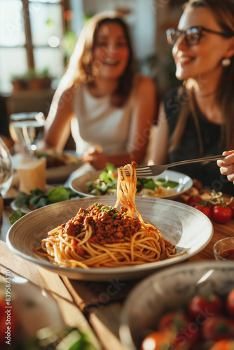 Happy group of friends eating pasta at home dinner party - Cheerful young people having lunch break together - Life style concept with guys and girls celebrating thanksgiving - Bright filter