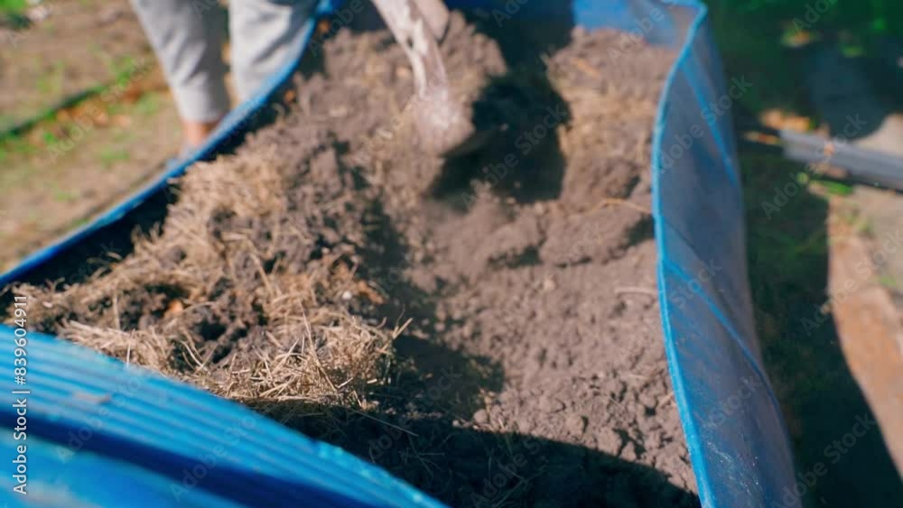 Plowing the soil in a homemade bed made from a plastic barrel Plowing the soil in a homemade bed made from a plastic barrel