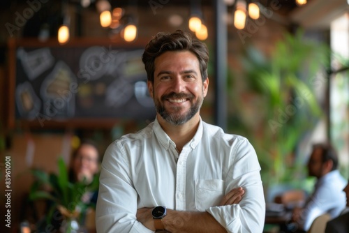Man smiling standing white shirt arms crossed restaurant