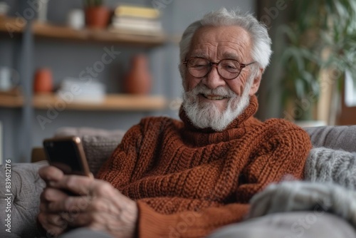 Elderly man on sofa with cellphone