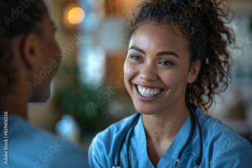 Happy nurse in blue scrubs conversing with a colleague