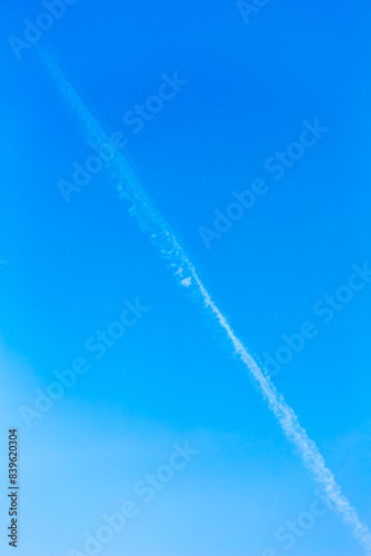 Landscape with beautiful cloudless blue sky background. with a white contrail. Beauty clear cloudy in sunlight calm bright winter or summer windy air background. Can be used as wallpaper.