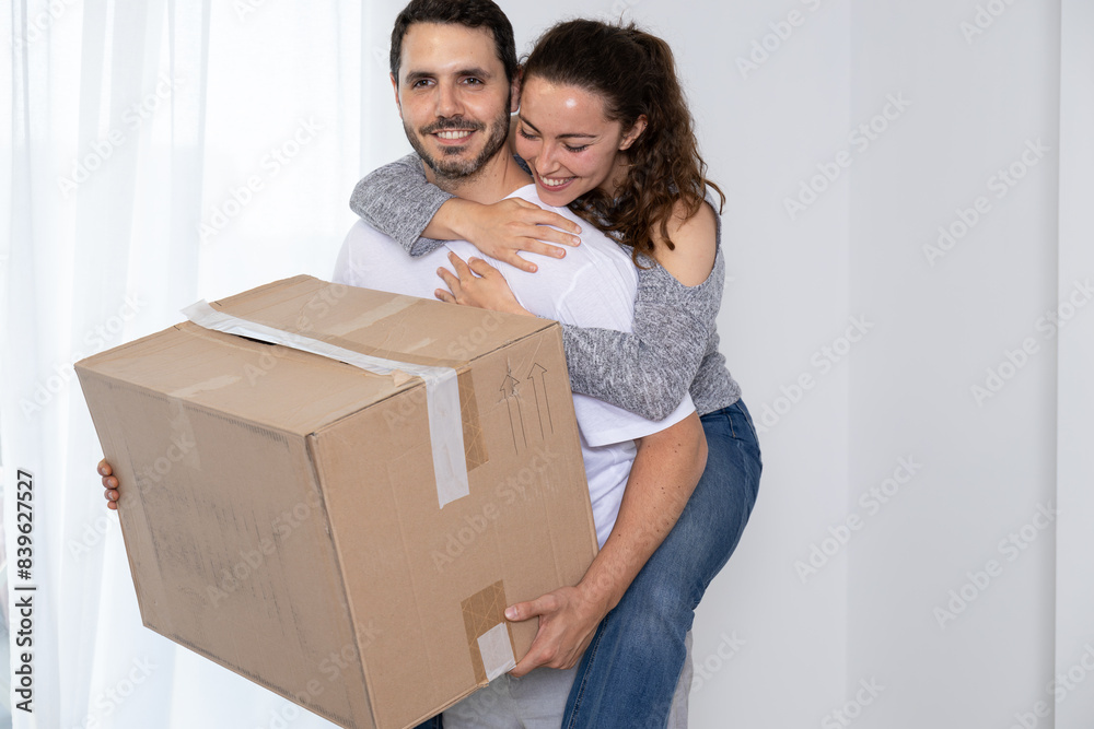 Happy couple packing their stuff to move into their new owned house. They are homeowners, mortgage concept. New home, new life