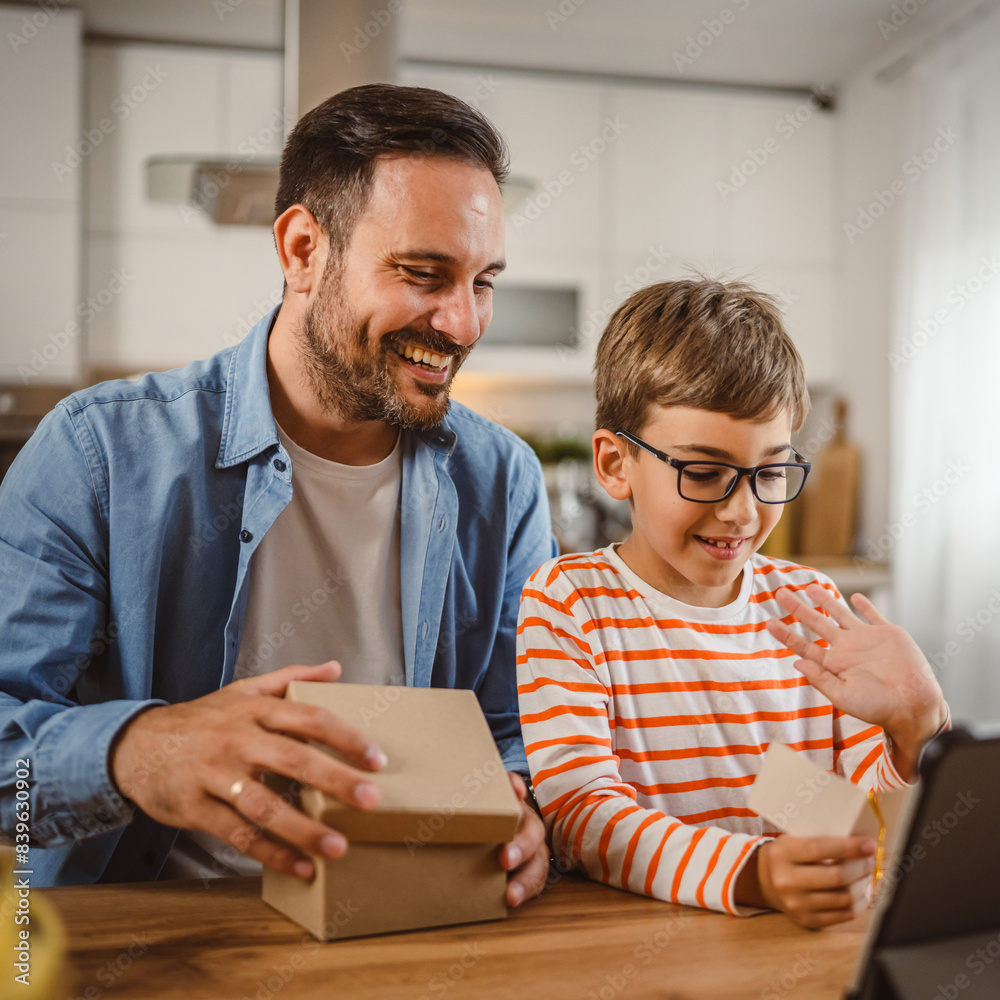 Father and son read card together at home with tablet on the table Father and son read card together at home with tablet on the table