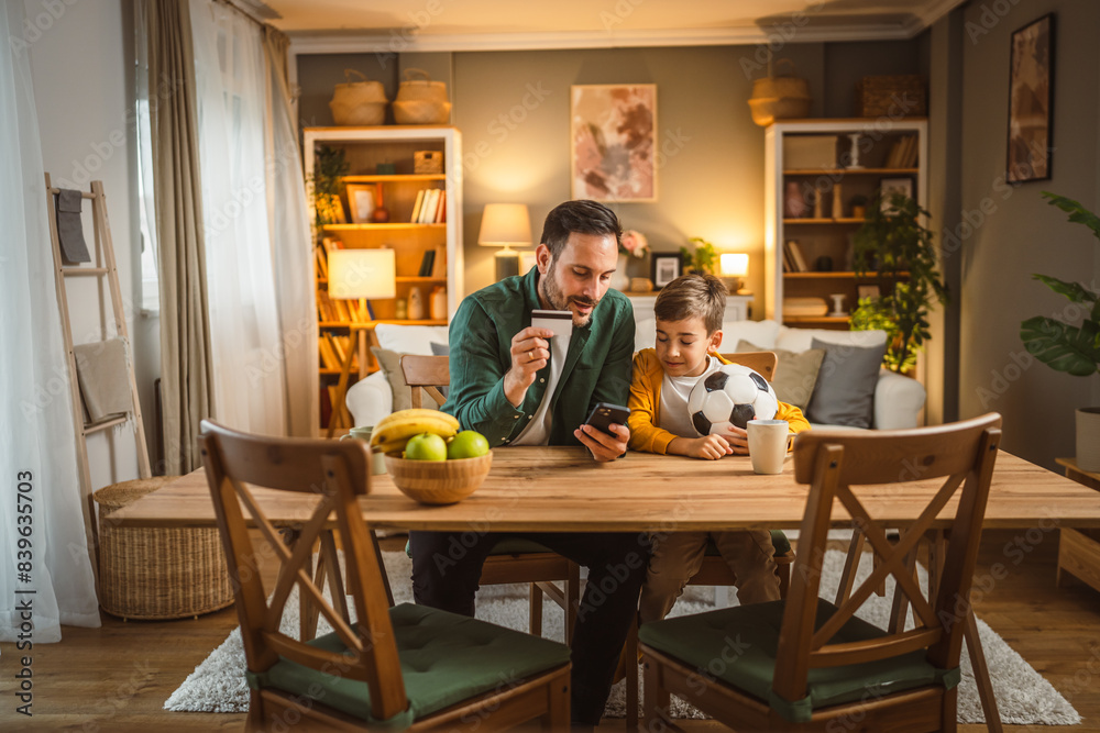 Dad and son have online shopping on cellphone with credit card Dad and son have online shopping on cellphone with credit card