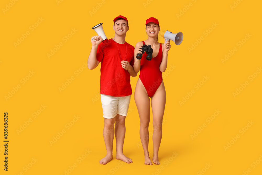Lifeguards with binoculars and megaphones on yellow background Lifeguards with binoculars and megaphones on yellow background