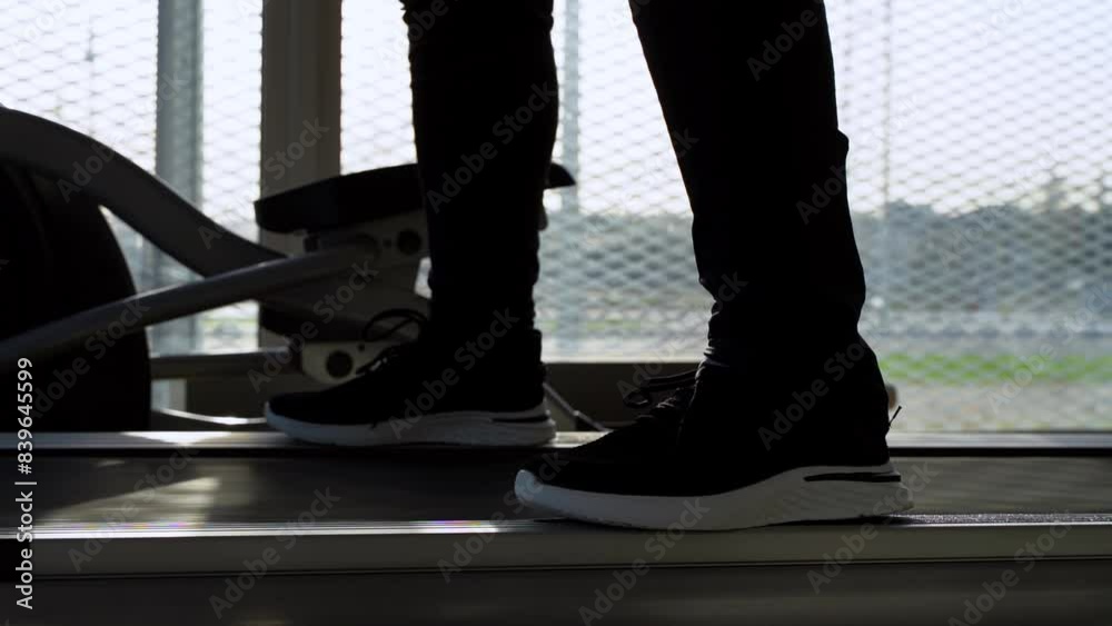 Athlete in sunny gym on treadmill, selective focus Athlete in sunny gym on treadmill, selective focus