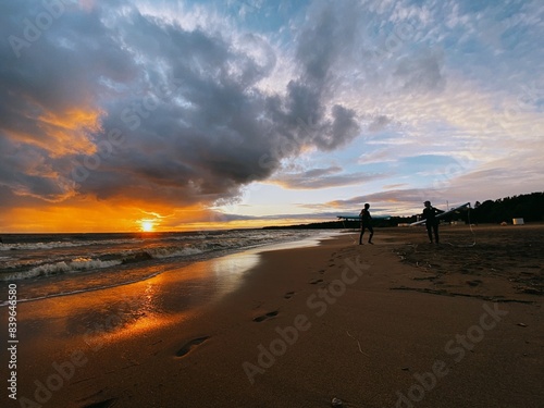 surfing sportsmen try to catch waves in the baltic sea finnish bay at sunset and wetsuits, cool fresh sea