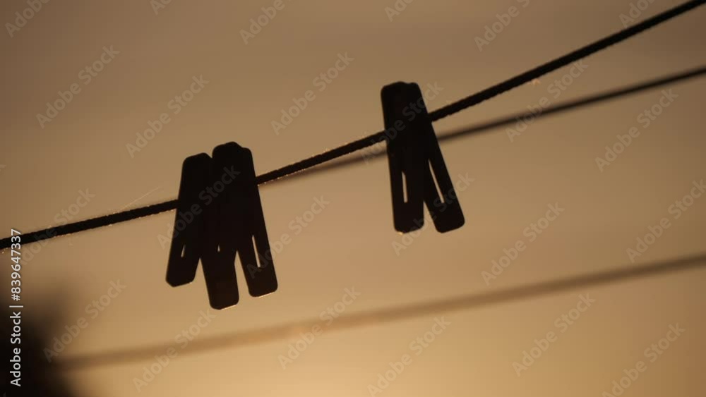 Silhouette Of A Plastic Clothespins Hang In A Row On The Rope Silhouette Of A Plastic Clothespins Hang In A Row On The Rope