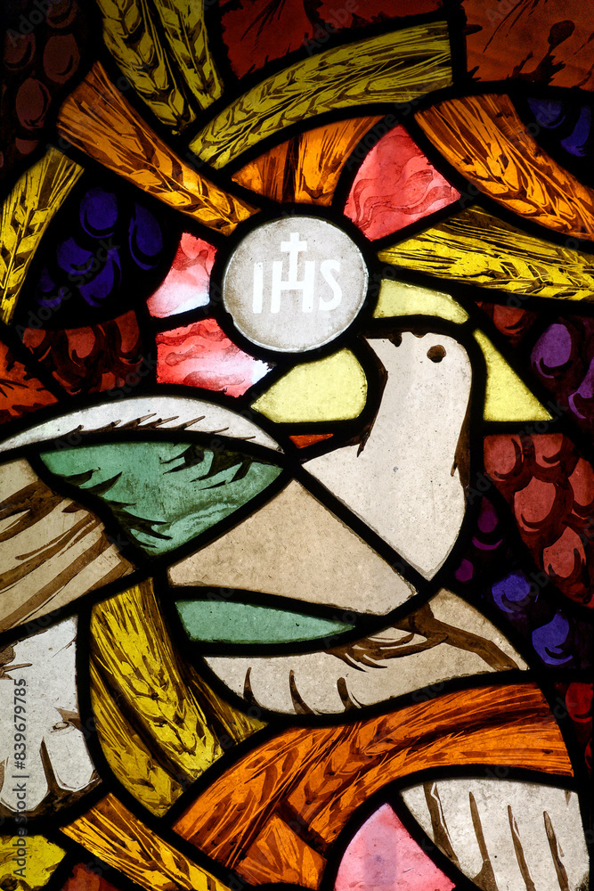 stained glass window depicting a dove of peace symbolizing the holy spirit bringing the eucharist.  vitrail moderne représentant une colombe de la paix symbolisant l’ esprit saint apportant l’eucharis
