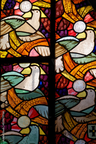 stained glass window depicting a dove of peace symbolizing the holy spirit bringing the eucharist.  vitrail moderne repr  sentant une colombe de la paix symbolisant l    esprit saint apportant l   eucharis