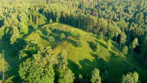 Scenic aerial view of Stirniai mound surrounded with green trees, located in Neris Regional Park near Vilnius, on sunny summer day. Landmarks and destination scenics of Lithuania. photo
