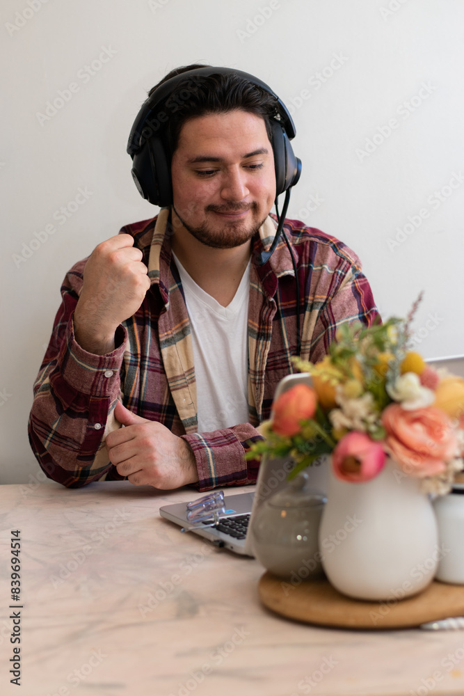 Man using headset and preparing to play and get fun with his laptop in the living room Man using headset and preparing to play and get fun with his laptop in the living room
