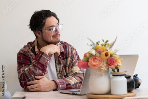 Happier man looking to the horizon while are using his laptot in the living room photo